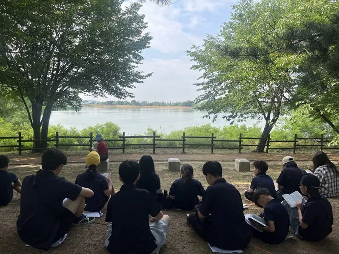 야외에 둘러앉아 말씀을 나누는 학생들